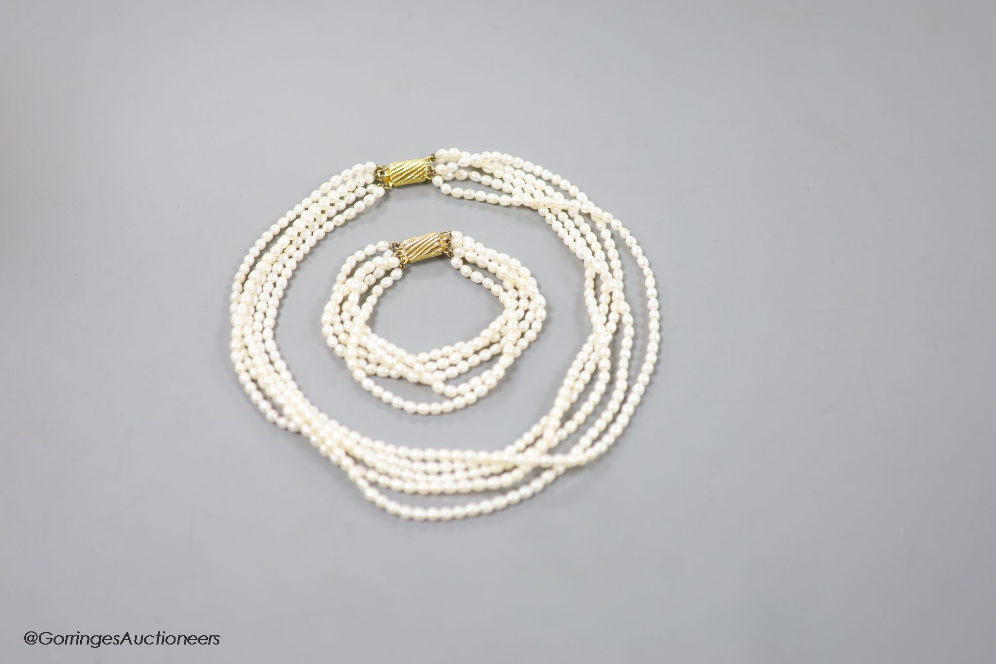 A modern multi strand cultured pearl necklace, with gilt metal clasp, 38cm and a matching bracelet, 17cm.